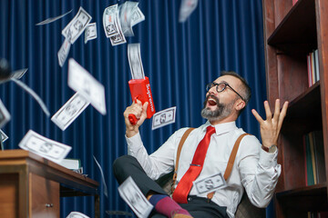 happy bearded business man play money gun shooting banknote