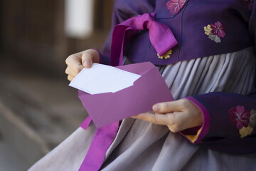 Woman in Korean traditional clothes holding gift voucher