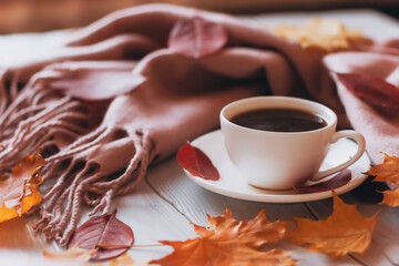 Autumn cozy home composition with a cup of coffee and leaves