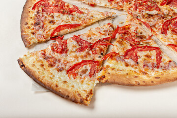 Pizza margarita on a light background. A slice of margarita pizza. Pizza with tomatoes.