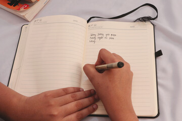 Boy Hands showing writing diary at home 