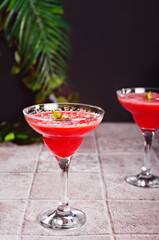 Watermelon refreshing summer frozen cocktail smoothie with watermelon slices and pieces on the background