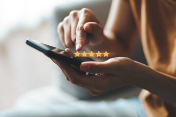 Close up of woman customer giving a five star rating on smartphone. Review, Service rating, satisfaction, Customer service experience and satisfaction survey concept.. - obrazy, fototapety, plakaty