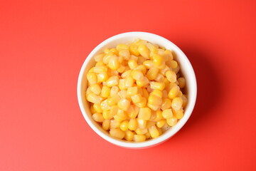 Bowl of sweet corn in white bowl  on red background