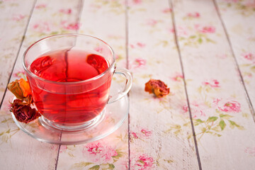 cup of herbal red tea with dry roses hibiscus
