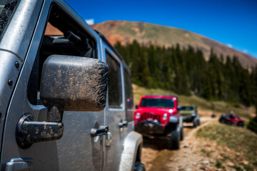 Mud covers the rear-view mirror of a vehicle while 4-wheeling up Revenue Mountain in the Upper Geneva Creek area near Grant, Colorado.