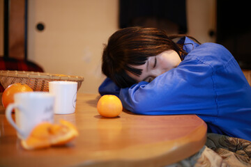 こたつで居眠りする女性
