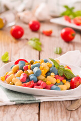 Colored gnocchi with vegetables and sweet corn.