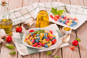 Colored gnocchi with vegetables and sweet corn.
