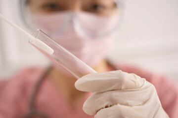 Doctor putting swab into tube	