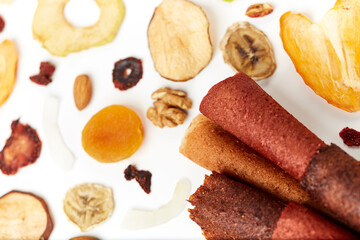 Above view of tasty lozenge with fruits and berries at table and dried fruits kiwi, orange, apple, apricot and bananas on white background. Concept of healthy assorted dried fruit for snacks.