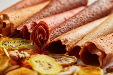 Close up of neatly stacked fruit lozenge different colors and almonds, orange, dried apricot, raisins, walnuts, dried apples and kiwi on white background. Concept of healthy snacks. 