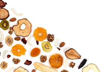Above view of well laid out dried fruits apples, mango, orange, dried apricots, kiwi, dried coconut and walnuts on white background. Concept of organic healthy assorted dried fruit for snacks.