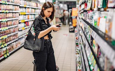 Young woman choosing care cosmetic in a supermarket