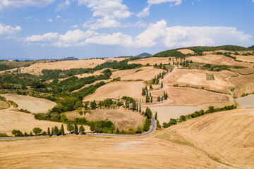 Obraz premium Top view of a road in Tuscany with farm fields, houses and blue sky, Italy
