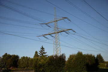 Obraz premium power pylon with power wires, blue sky as background, view from below