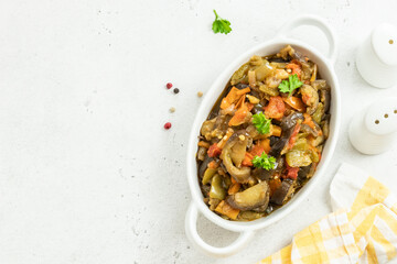 Roasted vegetables spicy  saute in baking dish. Space for text, top view