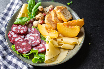 snack plate sausage, meat, cheese, nuts, peach, fruit, toast bread smoked or dry-cured meal snack on the table copy space food background rustic. top view