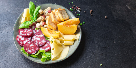 snack plate sausage, meat, cheese, nuts, peach, fruit, toast bread smoked or dry-cured meal snack on the table copy space food background rustic. top view