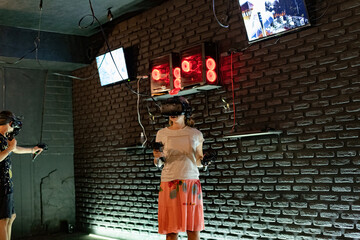 The girl in the virtual reality room plays computer games.