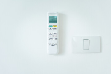 Remote control of air conditioner in holder on wall. Include symbol, digital display, infrared,...