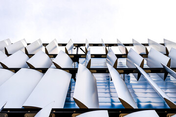 The facade of a modern building with an innovative facade made of automatic, movable blinds.