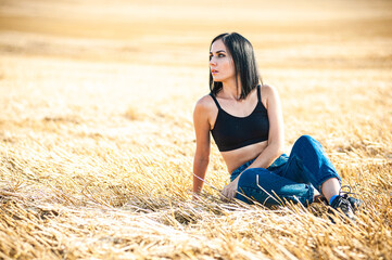 Naklejka na ściany i meble Beautiful young woman posing on the summer field 