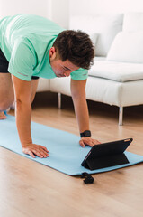 Young handsome Chinese man practicing yoga in the living room