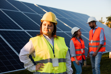 Overweight woman engineer posing at the solar station