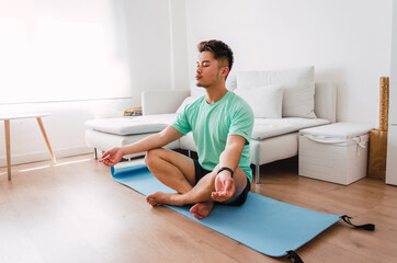 Young handsome Chinese man practicing yoga in the living room
