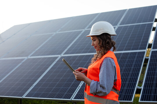 Female engineer is working with tablet at solar station