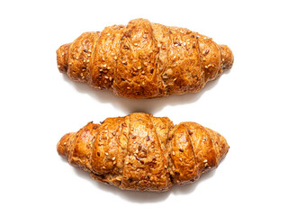 Two French croissants with a golden crust, sprinkled with seeds, on a white background. Top view
