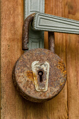 Old rusty padlock on the door handle.