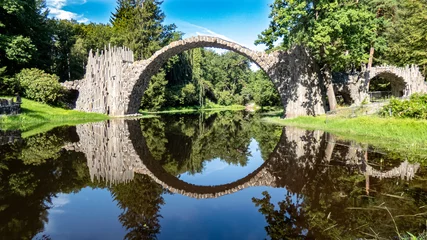 Zelfklevend Fotobehang Rakotzbrücke Rakotzbrücke Kromlau met een cirkelvormige weerspiegeling in het water in het Rhododendron Park