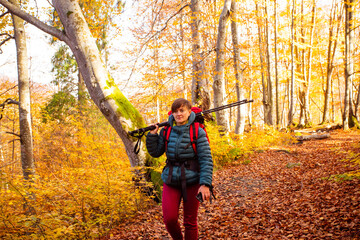 Fototapeta premium The woman hiker travels in the woods is looking around