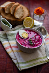 Cold borsch, summer beet soup with fresh cucumber and boiled egg in a white bowl. Traditional European food, delicious lunch