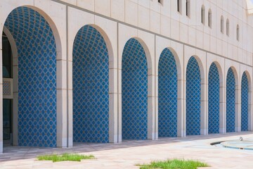 Perspective view to white facade wall of building with row of oriental arches ornate designed blue arabesque style tiles with geometric pattern