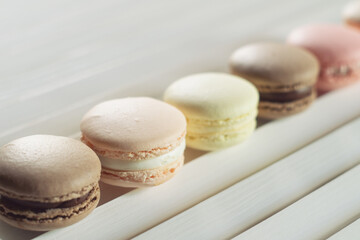 Multicolored macarons on white wooden table