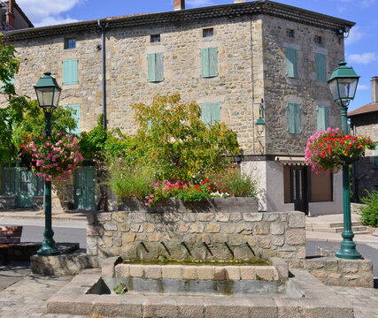 La fontaine et les géraniums de la place de la Mairie à Désaignes (07570), département de l'Ardèche en région Auvergne-Rhône-Alpes, France