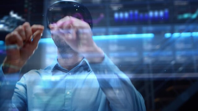 Young Adult Male Engineer Using Futuristic Augmented Reality Software Interface for Managing Work Projects. Specialist in Office Wearing Headset to Look at VFX Animation with Electric Car Concept.