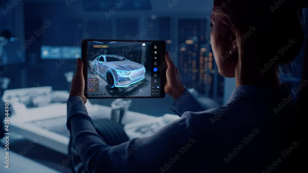Fototapete Automotive Engineer Working on Electric Car Chassis Platform, Using Tablet Computer with Augmented Reality 3D Software. Innovative Facility: Vehicle Frame with Wheels Becomes a VFX Virtual Model.
