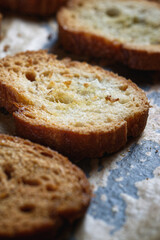 Crispy toasted slices of baguette bread, on a baking sheet 