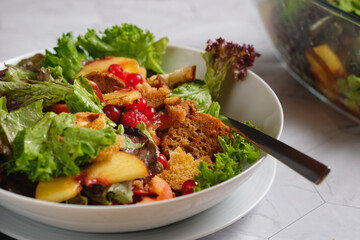 Colorful summer salad with tomatoes, nectarines, toasted bread and berry fruits.