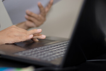 Close-up photo of a woman searching for information on her laptop to make use of it.