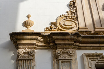 Detail of the exterior of the door of a church, with masonry pillars adorned with varied and classical forms.