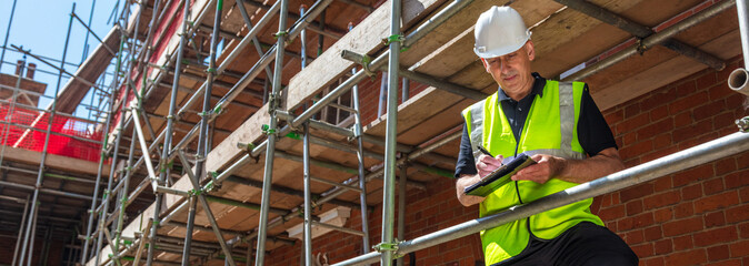 Panoramic Builder Construction Worker Contractor on Building Site Web Banner Header - 451047986