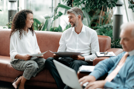 businessman and businesswoman discussing business and financial documents .