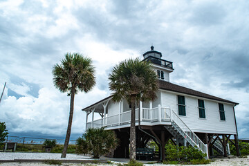 Port Boca Grande Lighthouse and Museum stand strong on Gasparilla Island as a tropical storm with black clouds loom of the coast in the Gulf of Mexico