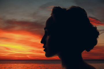 Woman silhouette with sun and clouds in her head