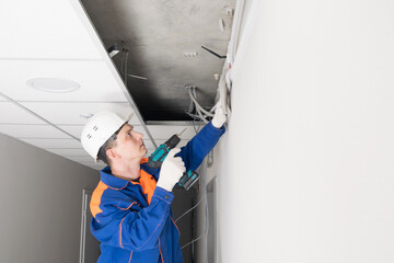 a worker installs a router on the wall to transmit the Internet signal in offices and homes, side view